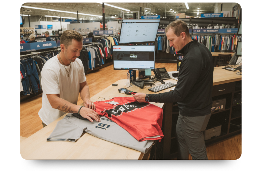 Customer and sales person discussing uniform tops at a sales counter. 
